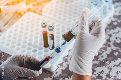 Medical laboratory scientist taking blood from the syringe to the tube for analysis blood collection and send to the blood bank. Blood Collection Concept.