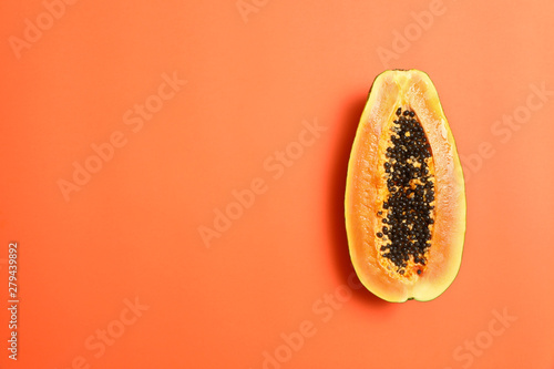Fresh juicy halved papaya on coral background, top view. Space for text photo