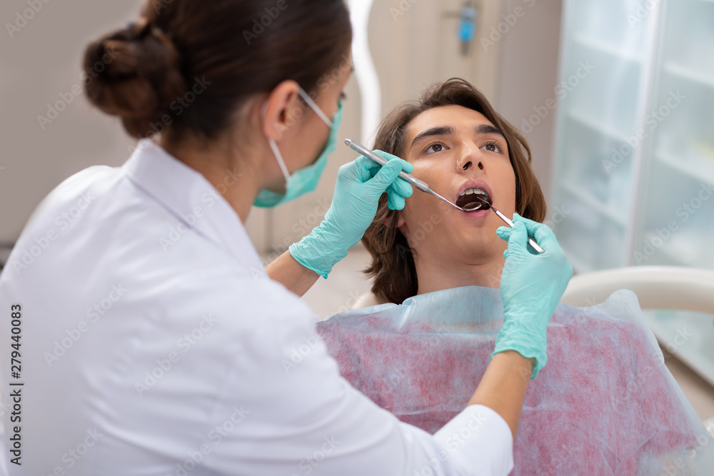 Calm handsome young man sitting at the dentists Calm handsome young man sitting at the dentists