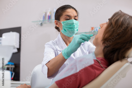 Dentist sitting in front of her male patient