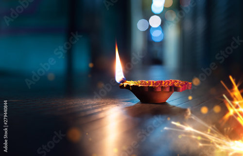 Canvas Print Happy Diwali - Lit diya lamp on street with firecrackers