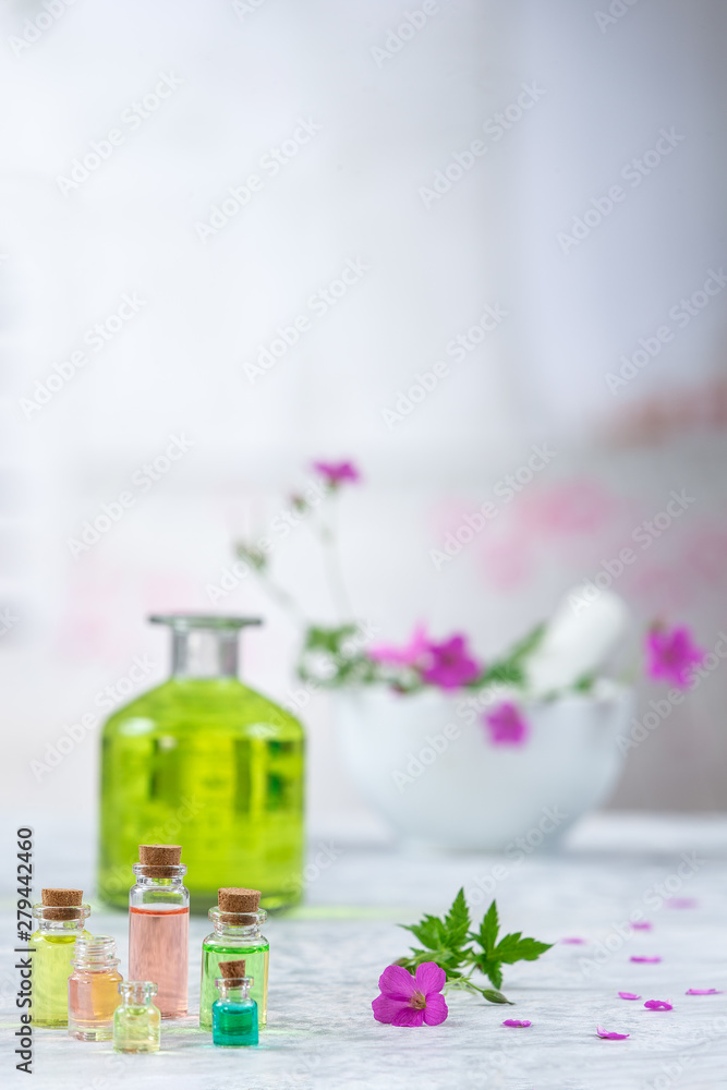 Essential geranium oil in bottle and geranium flowers,Meadow geranium essential oil