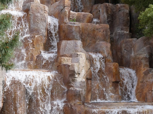 Fototapeta Naklejka Na Ścianę i Meble -  Close up of water rippling down rocks in a man-made waterfalls