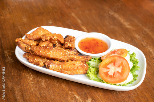 Fried chicken wings with chicken sauce on the dish.