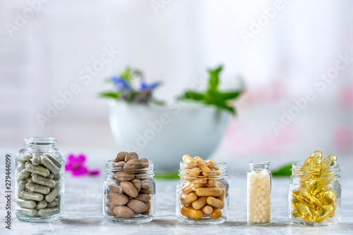 Herbal medicine pills with dry natural herbs Concept of herbal medicine and dietary supplements photo
