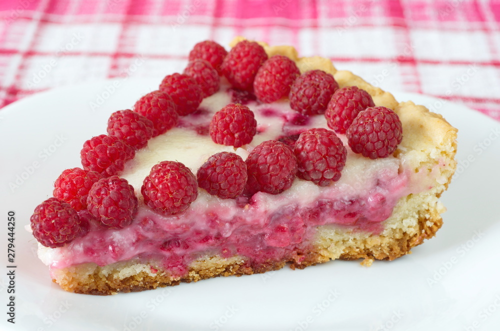A piece of shortbread pie with raspberry and sour cream on a plate close-up A piece of shortbread pie with raspberry and sour cream on a plate close-up