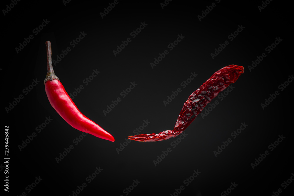 floating fresh red chili and dried chili on dark background floating fresh red chili and dried chili on dark background