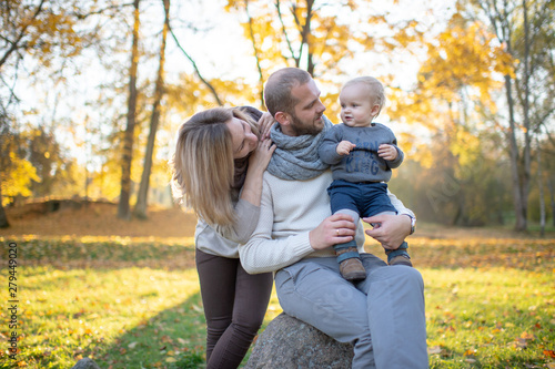 Happy family couple with child sincere emotions outdoor portrait.