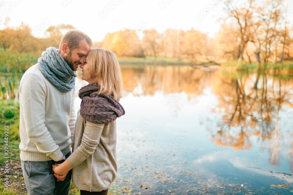 Fototapeta premium Loving para w romantyczny portret dzianiny z odbiciem jeziora na tle.
