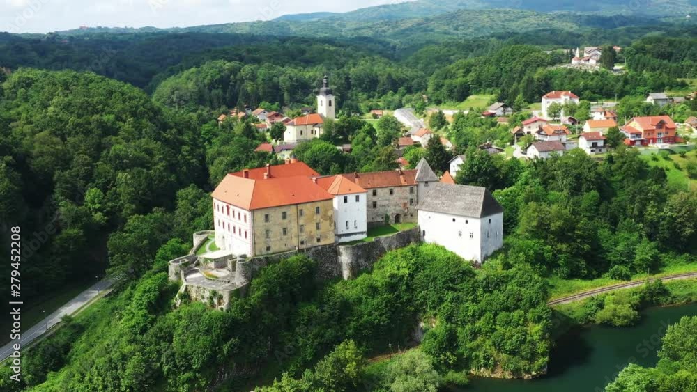 Panoramic view of the river Kupa and beautiful old Ozalj Castle on the hill in town of Ozalj, Croatia, drone flight aerial footage, circle shot Panoramic view of the river Kupa and beautiful old Ozalj Castle on the hill in town of Ozalj, Croatia, drone flight aerial footage, circle shot