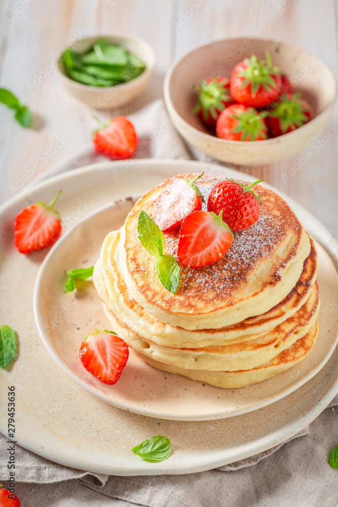 Homemade american pancakes with powdered sugar and sweet strawberries Homemade american pancakes with powdered sugar and sweet strawberries