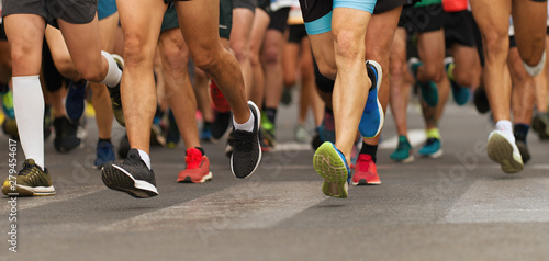 Maratończycy biegający po drogach miejskich, duża grupa biegaczy