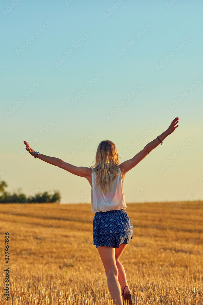 Cute young woman jumping in a wheat field. Cute young woman jumping in a wheat field.