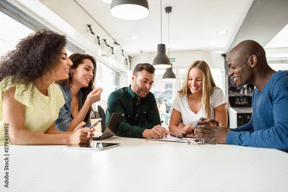 Multi-ethnic group of young people studying together on white desk Multi-ethnic group of young people studying together on white desk
