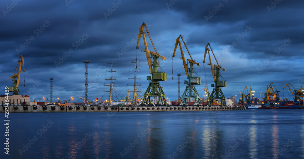 Obraz premium Panorama of the seaport with loading cranes at sunset