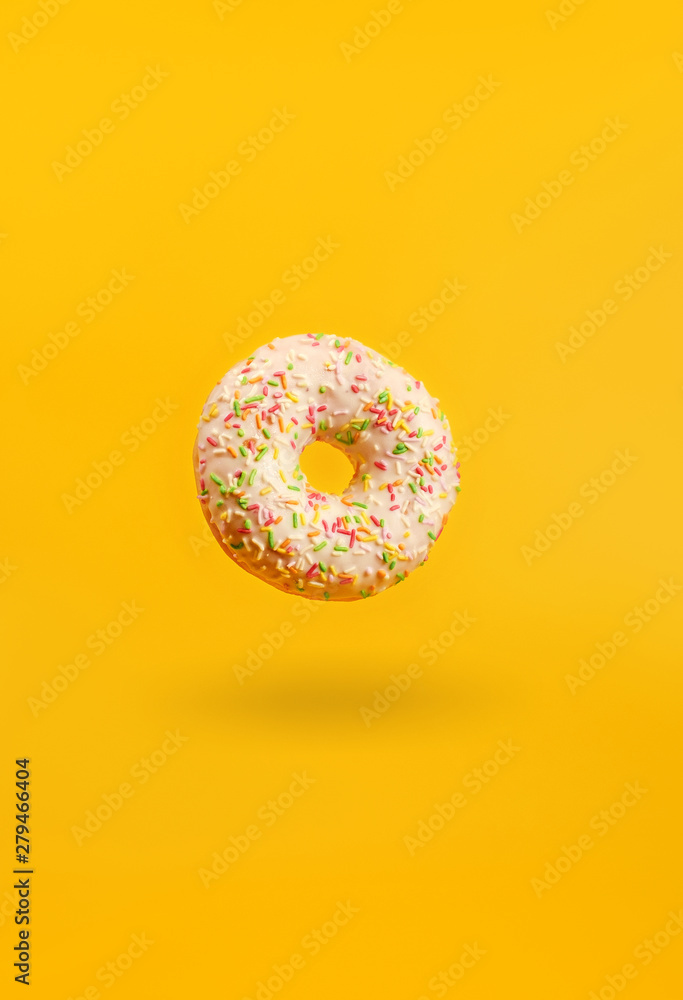 donut on a yellow background with shadow hanging in the air donut on a yellow background with shadow hanging in the air
