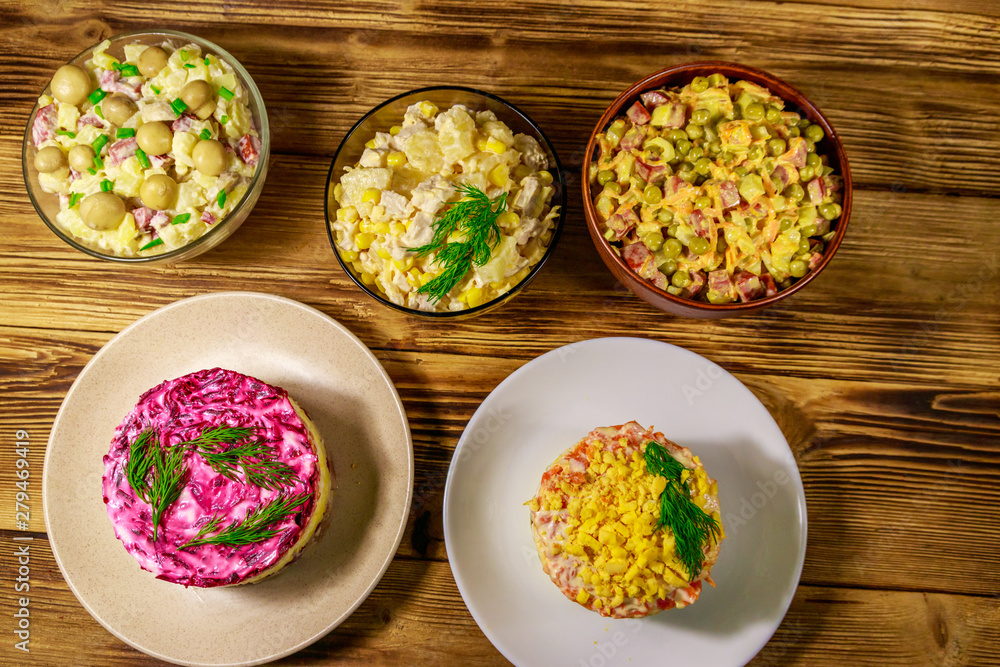 Set of festive mayonnaise salads on wooden table. Top view Set of festive mayonnaise salads on wooden table. Top view