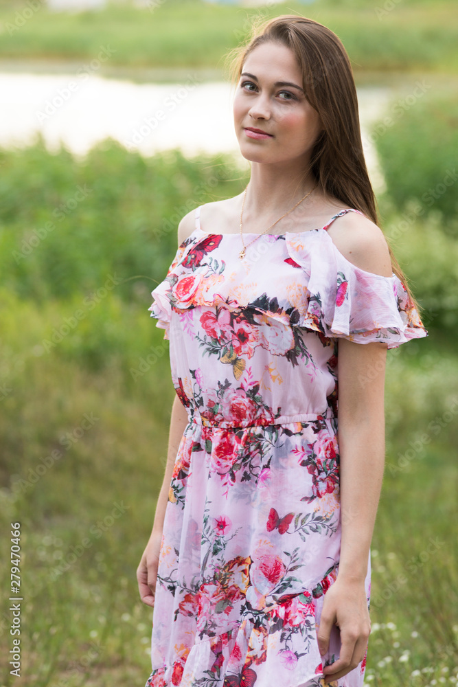 The young woman in a dress poses in the village The young woman in a dress poses in the village