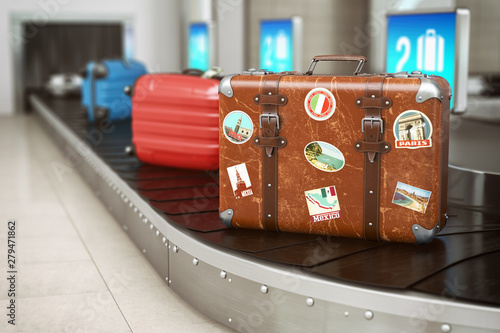 Old vintage suitcase on a airport luggage conveyor belt. Baggage claim. Travel and tourism concept background.