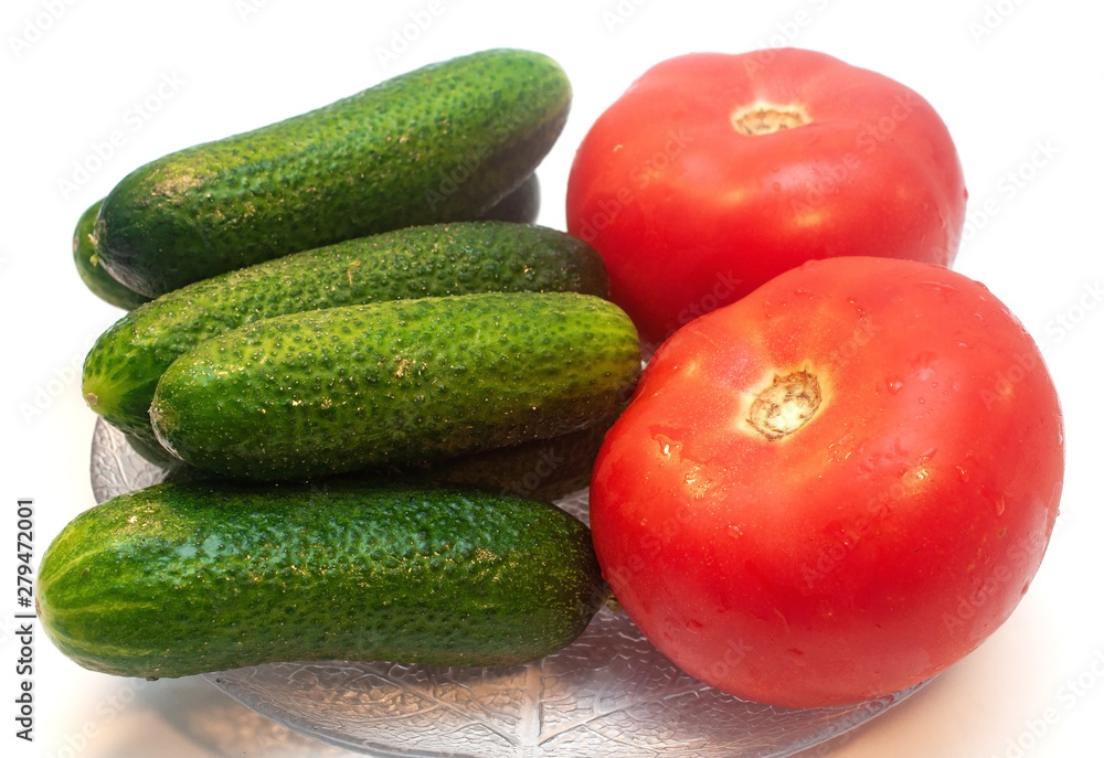 Cucumbers with tomatoes in a plate on a white background Cucumbers with tomatoes in a plate on a white background
