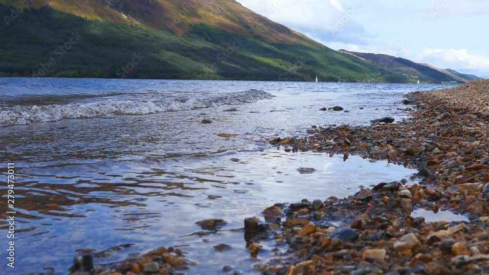 A shore of a mountain lake with small waves. A shore of a mountain lake with small waves.