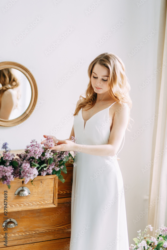  Wedding in European style. Stylish trendy bride in the Studio with a bouquet of lilacs.