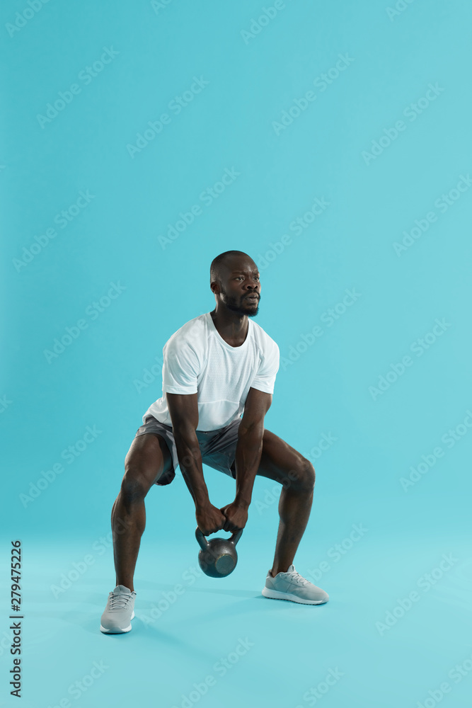 Fitness training. Sports man doing kettlebell squat workout