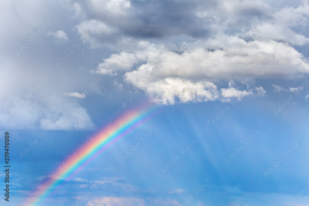 Natural rainbow and clouds in the sky. Bright, colorful background art design.