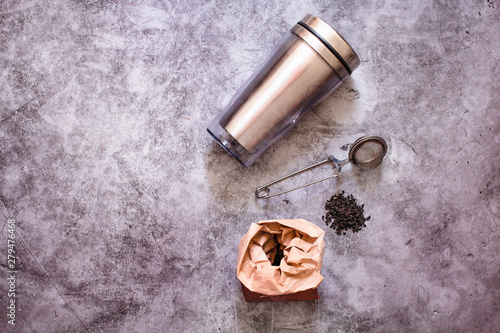 Great black tea loose leaf on gray background. Eco-friendly alternatives.Metal thermos and tea infuser.Eco friendly Zero waste plastic free
