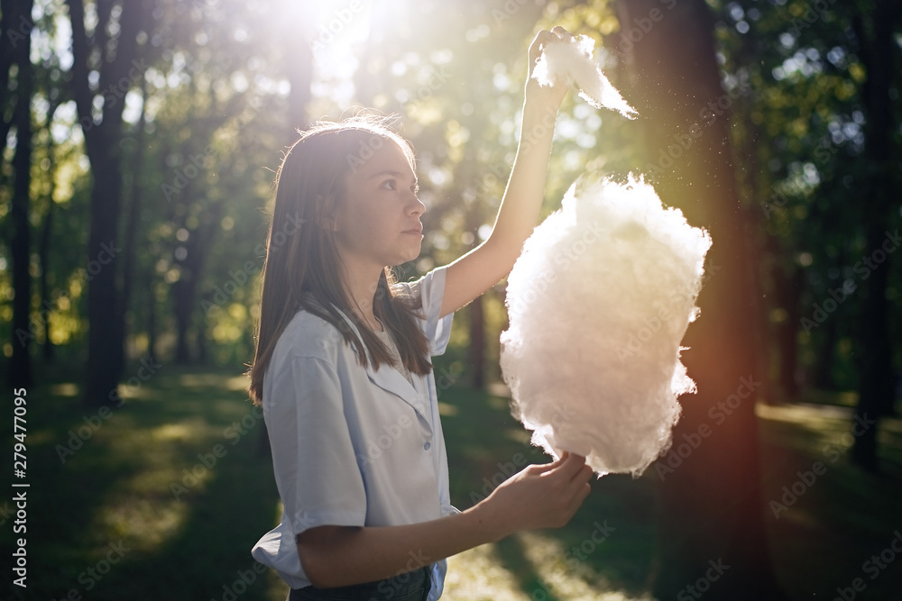Portrait of a pretty young girl eating cotton candy at park Portrait of a pretty young girl eating cotton candy at park