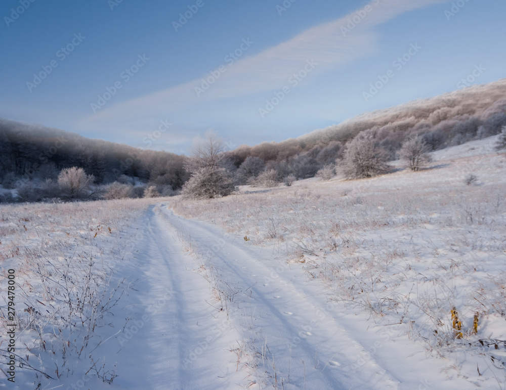 road through the winter mountain valley in a snow