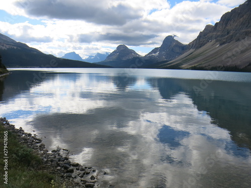 Moody skies reflected in the glacial Bow Lake in the Canadian Rockies