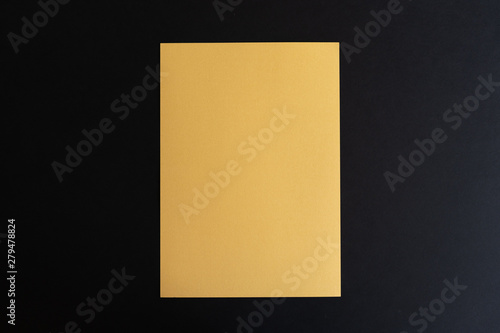 Blank gold paper sheet on black background. Layout for business, posters and banners.