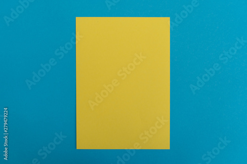 Blank yellow paper sheet on blue background. Layout for business, posters and banners.