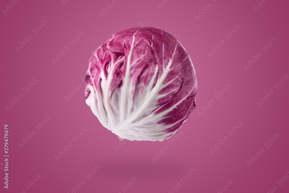 Obraz premium whole red radicchio over purple background, healthy vegetarian food