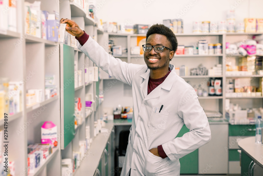 African-american man pharmacist on his workplace in modern drugstore. Health care medical background.