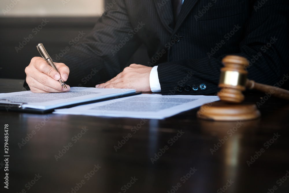 Legal counsel presents to the client a signed contract with gavel and legal law. justice and lawyer concept. Legal counsel presents to the client a signed contract with gavel and legal law. justice and lawyer concept.