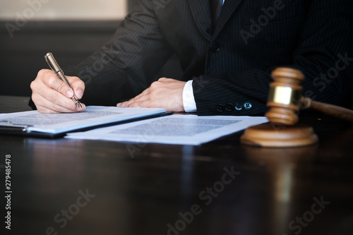 Legal counsel presents to the client a signed contract with gavel and legal law. justice and lawyer concept. photo