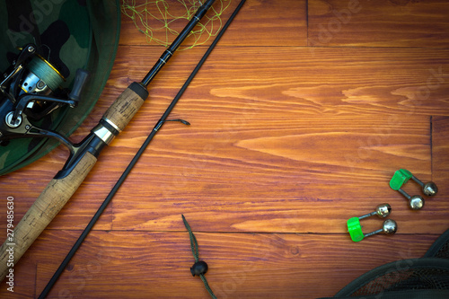 Fishing tackle-fishing spinning rods, hooks, floats and lures on wooden background