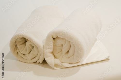 Two roll of white towel on bed