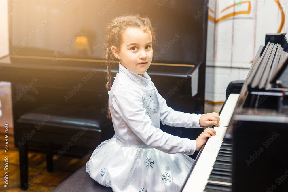 Little girl playing piano indoors Little girl playing piano indoors