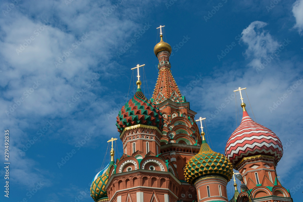 Multicolor towers of St. Basil's Cathedral against the cloudy sky.
