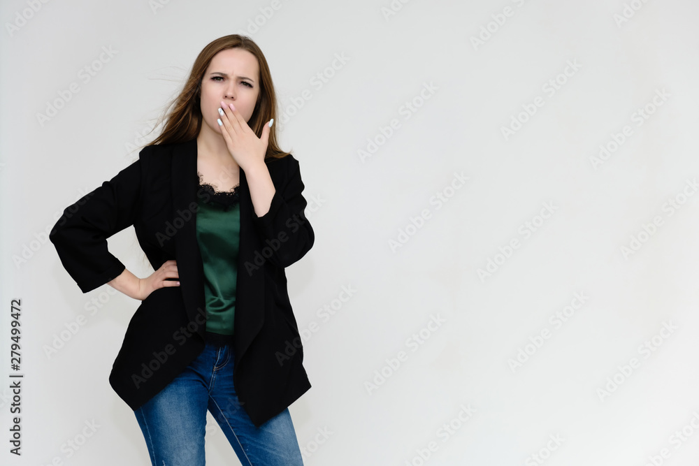 Concept portrait above the knee of a pretty girl, a young woman with long beautiful brown hair and a black jacket and blue jeans on a white background. In studio in different poses showing emotions. Concept portrait above the knee of a pretty girl, a young woman with long beautiful brown hair and a black jacket and blue jeans on a white background. In studio in different poses showing emotions.