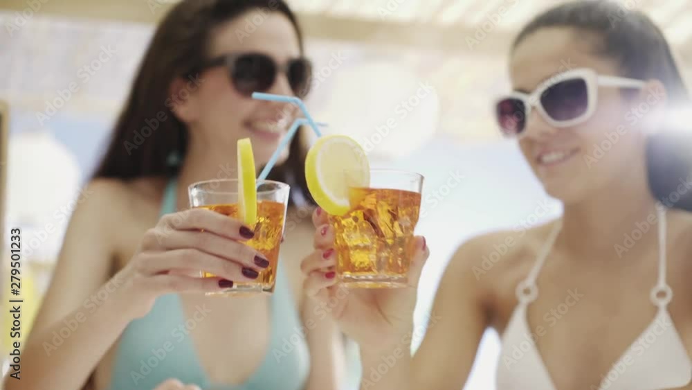 Happy girls drinking together and taking selfies at the beach Happy girls drinking together and taking selfies at the beach