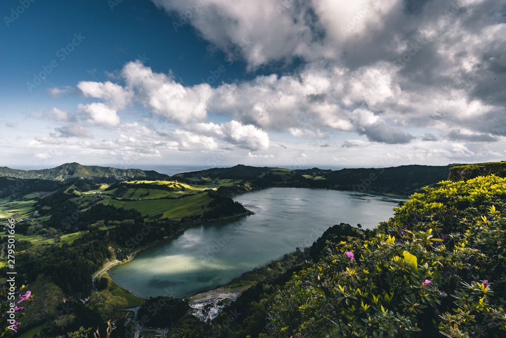 Panoramic landscape with aerial view on beautiful blue green crater lake Lagoa das Furnas and village Furnas with vulcanic thermal area. Sao Miguel, Azores, Portugal. Countryside landscape with green