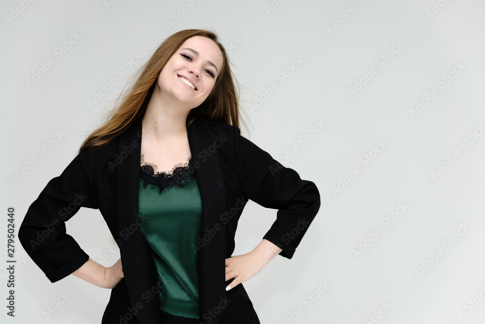 Concept portrait for the waist of a pretty girl, a young woman with long beautiful brown hair and a black jacket and blue jeans on a white background. In studio in different poses showing emotions. Concept portrait for the waist of a pretty girl, a young woman with long beautiful brown hair and a black jacket and blue jeans on a white background. In studio in different poses showing emotions.
