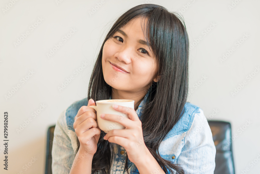 Beautiful asian women hold hot coffee cup in cafe Beautiful asian women hold hot coffee cup in cafe