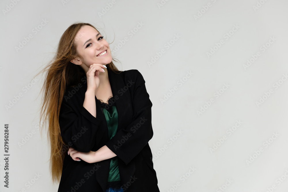 Concept portrait for the waist of a pretty girl, a young woman with long beautiful brown hair and a black jacket and blue jeans on a white background. In studio in different poses showing emotions. Concept portrait for the waist of a pretty girl, a young woman with long beautiful brown hair and a black jacket and blue jeans on a white background. In studio in different poses showing emotions.