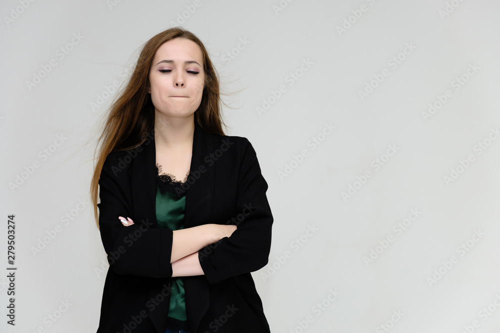 Concept portrait for the waist of a pretty girl, a young woman with long beautiful brown hair and a black jacket and blue jeans on a white background. In studio in different poses showing emotions. Concept portrait for the waist of a pretty girl, a young woman with long beautiful brown hair and a black jacket and blue jeans on a white background. In studio in different poses showing emotions.