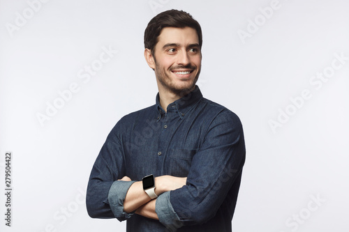 Obraz na plátně Ambitious guy looking sideways with arms crossed as if planning strategy of busi